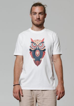 Witte katoenen t-shirt met een kleurrijk uil graphic design met ingewikkelde details in rood, blauw en zwart. Korte mouwen en ronde hals.