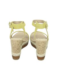 Yellow suede heeled sandals with an ankle strap, cork wedge heel, and jute detailing along the base. Smooth inner lining and buckle closure.