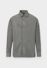 Chemise grise à boutons dans un tissu texturé, avec un col classique et des manches longues avec des fermetures à bouton sur le devant.