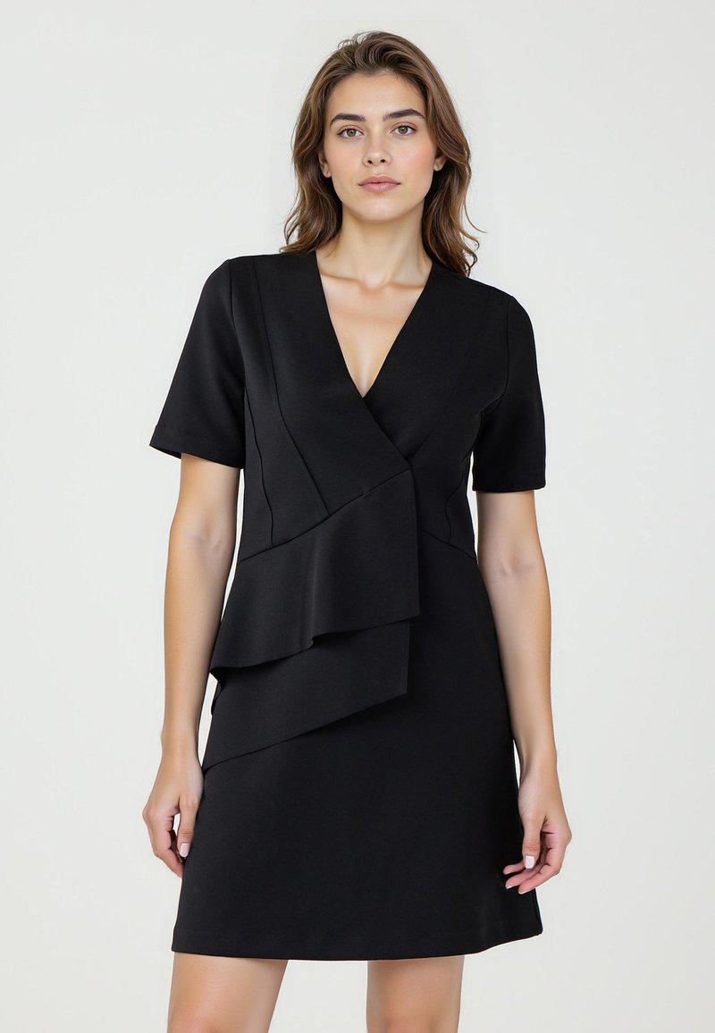 Robe noire à manches courtes, décolleté en V profond et détail de volant asymétrique à l'avant. Fabriquée à partir d'un tissu lisse et extensible.