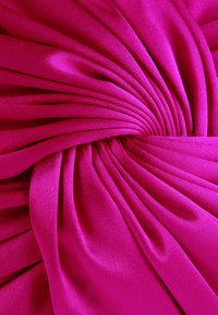 Tejido fucsia con una textura suave y brillante, que presenta sutiles pliegues que forman un patrón espiral en el centro.