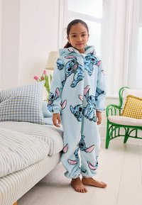 Vaaleansininen fleece-yhdiste, jossa on sarjakuvahahmo Stitchin kuvia, hupullinen, pitkät hihat ja joustavat hihnat nilkoissa.