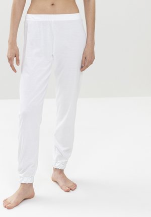 Pantalones jogger blancos de algodón con cintura elástica y puños fruncidos en los tobillos, con una textura suave.