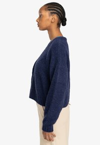 Marineblauw cropped sweater van textuurgebreid materiaal, met lange mouwen en een geribde zoom. Geen zichtbare versieringen.