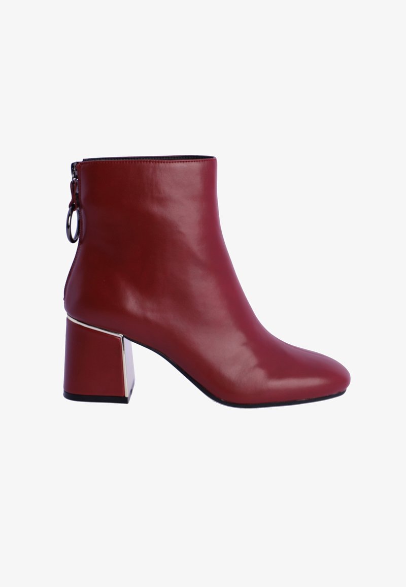 Botín de cuero burdeos con punta afilada y un tacón geométrico grueso que presenta un acento plateado. Cierre con cremallera en la parte posterior. Textura suave.