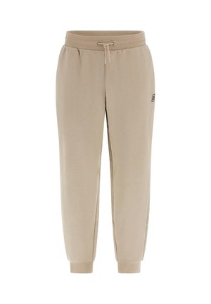 Beige jogger pants in soft fabric, featuring an elastic waistband with drawstring, cuffed ankles, and a small logo detail on the side.