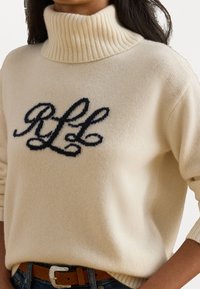 Suéter bege de gola alta feito de tecido macio com colarinho canelado; apresenta lettering escuro bordado "RLL" na frente.