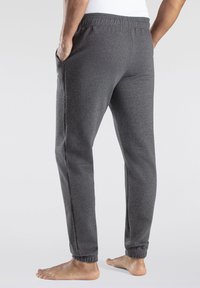 Gray sweatpants with elastic waistband and cuffs, side pockets, and a soft, textured fabric. No visible patterns or logos.
