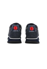 Sneaker blu navy con un accento circolare rosso sul tallone, con parte superiore in suede e mesh, suola intermedia bianca e suola testurizzata.