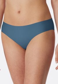 Modré spodní díly bikin s hladkou texturou, nízkým střihem a širokým elastickým pasem. Látka působí měkce a pružně. Bez vzorů a kovových prvků.