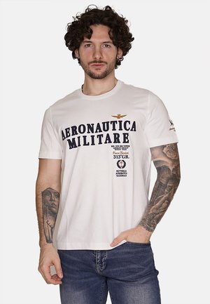 T-shirt in cotone bianco con testo blu "AERONAUTICA MILITARE", caratterizzata da grafiche e accenti ricamati; maniche corte, scollo rotondo.