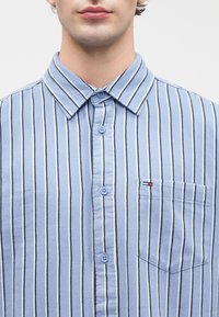 Blauw gestreept overhemd met knopen, gemaakt van katoen, met verticale strepen in lichtblauw en zwart, een borstzak en ronde knopen.