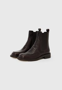 Botas negras de tobillo con un frente texturizado con patrón de cocodrilo, lados lisos, paneles elásticos y un tacón bajo en bloque.