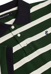 Grön- och vitrandig polo-shirt med marinblå krage, tre knappar och broderade initialer "PC" på vänster sida. Texturerat tyg.