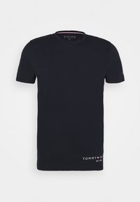Námořnická modrá krátkosrstá tričko s kulatým výstřihem, se malým logem "Tommy Hilfiger" a vlajkou poblíž lemu a rukávu.