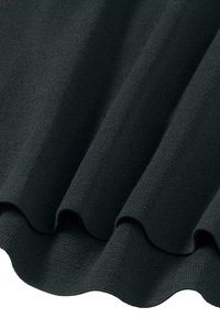 Tumma, teksturoitu kangas, jossa on pehmeä, neulottu ilme ja aallotteleva reuna. Pintaa koristi hieno, sileä kuosi ja syvä väri.