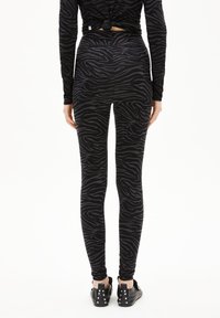 Zwarte legging met een zebrapatroon, voorzien van een hoge tailleband en een aansluitend ontwerp. Soepele textuur, geschikt voor sportkleding.