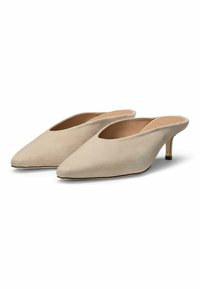 Beige suede mules with a pointed toe and a cut-out design. Features a small metallic heel and a smooth interior lining.