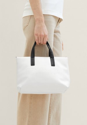 Sac tote blanc avec poignées noires, forme rectangulaire, surface texturée, logo en relief et fermeture éclair.