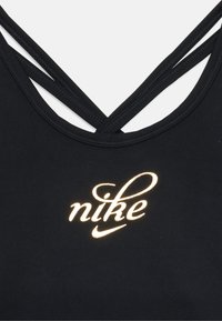 Top sportivo nero con spalline incrociate sottili e un logo "nike" stilizzato e luminoso in oro al centro frontale.