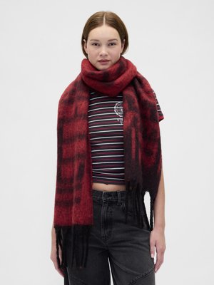 Κόκκινο και μαύρο καρό κασκόλ από απαλό ύφασμα, με φουντωτές άκρες, τυλιγμένο γύρω από το λαιμό, συνδυασμένο με ριγέ τοπ.