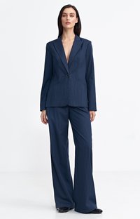 Granatowy garnitur w paski z wyraźną marynarką na jeden guzik i szerokimi spodniami. Gładki materiał z delikatnym połyskiem.