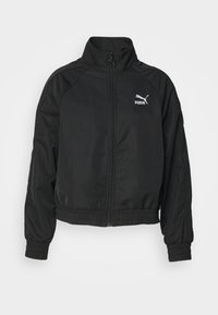 Schwarze Zip-Jacke mit hohem Kragen, elastischen Bündchen und Saum. Mit weißem Puma-Logo. Hergestellt aus glattem, leichtem Stoff.