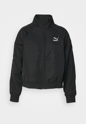 Veste noire zippée avec col montant, poignets et ourlet élastiques. Présente le logo Puma en blanc. Fabriquée en tissu lisse et léger.