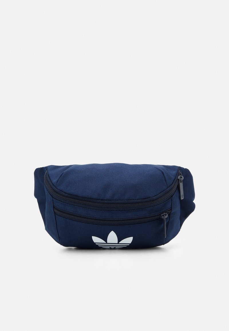 Marineblått tygbälte med två fickor med dragkedja och en vit logotyp på framsidan. Rundad form, mjuk yta och hållbart material.