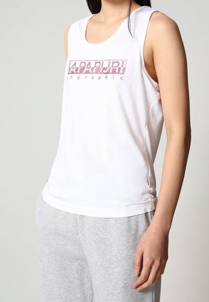 Weißes ärmelloses Tanktop mit Rundhalsausschnitt, vorne mit pinkem grafischem Schriftzug, kombiniert mit grauen Jogginghosen.