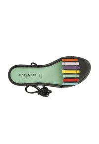 Sandalia negra con una plantilla texturizada verde, que presenta rayas multicolores en rojo, naranja, púrpura, azul y amarillo en la parte superior.