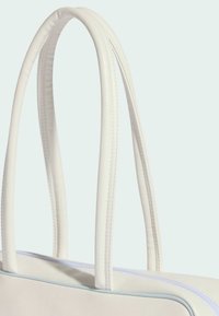 Bijela torba za nošenje od sintetičkog materijala s glatkom teksturom, dva dugačka držača i svijetlo plavom patentnom zatvaraču duž gornjeg ruba.