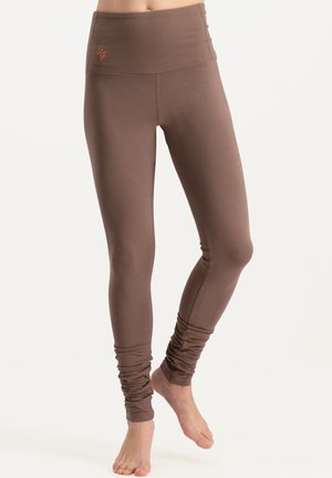 Braune hoch taillierte Leggings mit glatter Textur, schmal zulaufenden Beinen und gerafften Knöchel-Details. Mit einem kleinen Logo in der Nähe des Bundes.