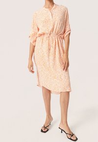 Šaty s květinovým potiskem v oranžové a bílé barvě, s mandarin límcem, krátkými rukávy a nastavitelným stahovacím pasem, s mírně asymetrickým lemem.