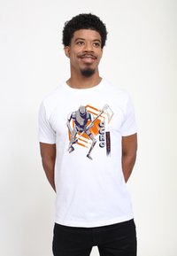 Hvid bomulds T-shirt med et grafisk motiv af en robot, der svinger et værktøj, med orange og marineblå accenter og teksten "OCHO."