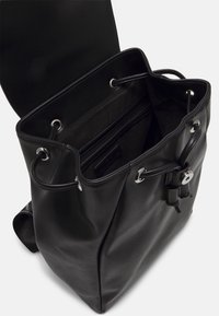 Svart läder bucket-väska med dragsko-stängning, silverdetaljer och ett zip-försett innerfack. Slät textur, mjuk form.