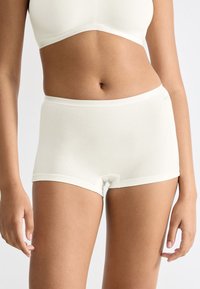 Vita bomullsboxershorts med en slät textur och elastiskt midjesnitt, med en mid-rise skärning och sömlösa kanter för komfort.