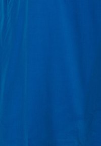 Tissu bleu uni avec des plis subtils et une texture lisse, éclairé uniformément sans motifs ni objets supplémentaires.