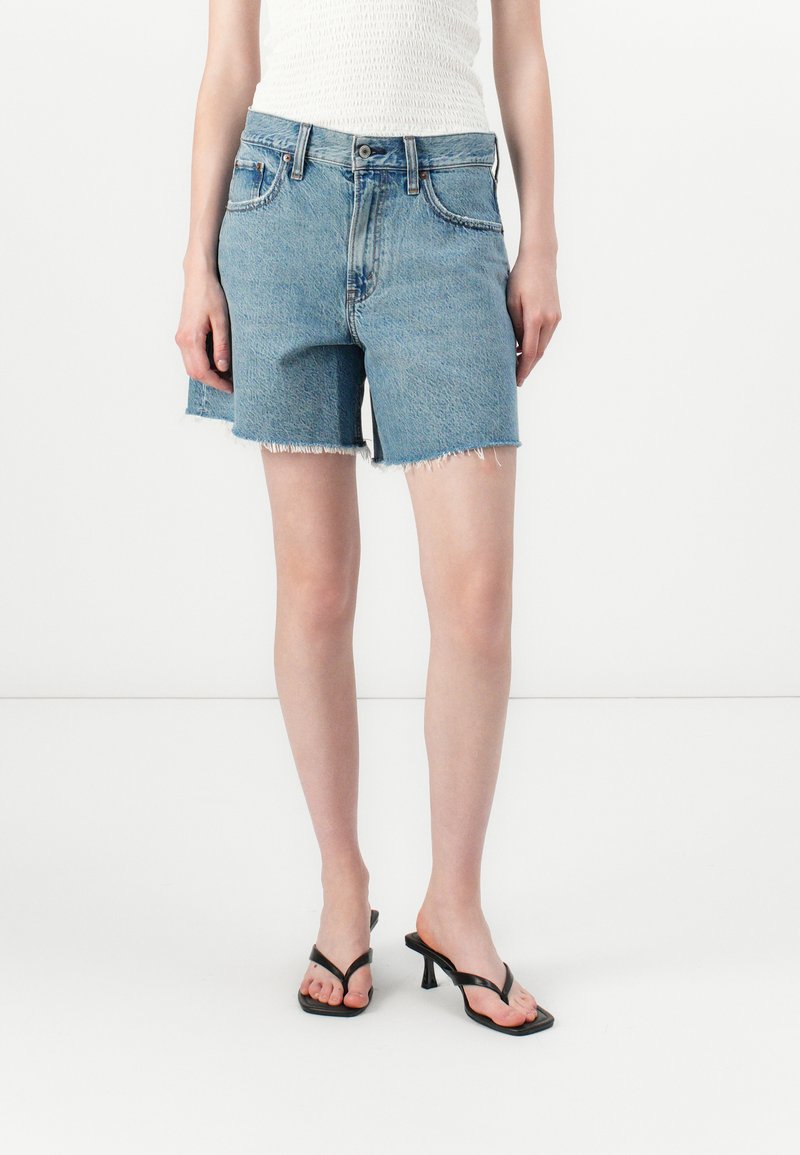 Lichtblauwe denim shorts met een rauwe zoom, voorzien van een klassiek vijf-pocket ontwerp en een sluiting met knoop aan de voorkant. Ruwe textuur, casual pasvorm.