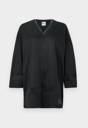 Black Nike short-sleeve jersey with a V-neck, featuring vertical ribbing, stitched accents, and a logo on the left chest. Lightweight fabric.