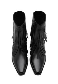 Botas de tobillo de cuero negro con detalles de flecos, punteras puntiagudas y una textura suave; cuentan con un diseño elegante y minimalista con poco adorno en el hardware.
