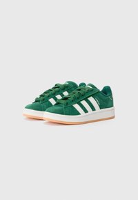 Grønne semskede sneakers med hvide striber, rund tå, snørelukning og beige gummisål. Teksten "CAMPUS" trykt på siden.