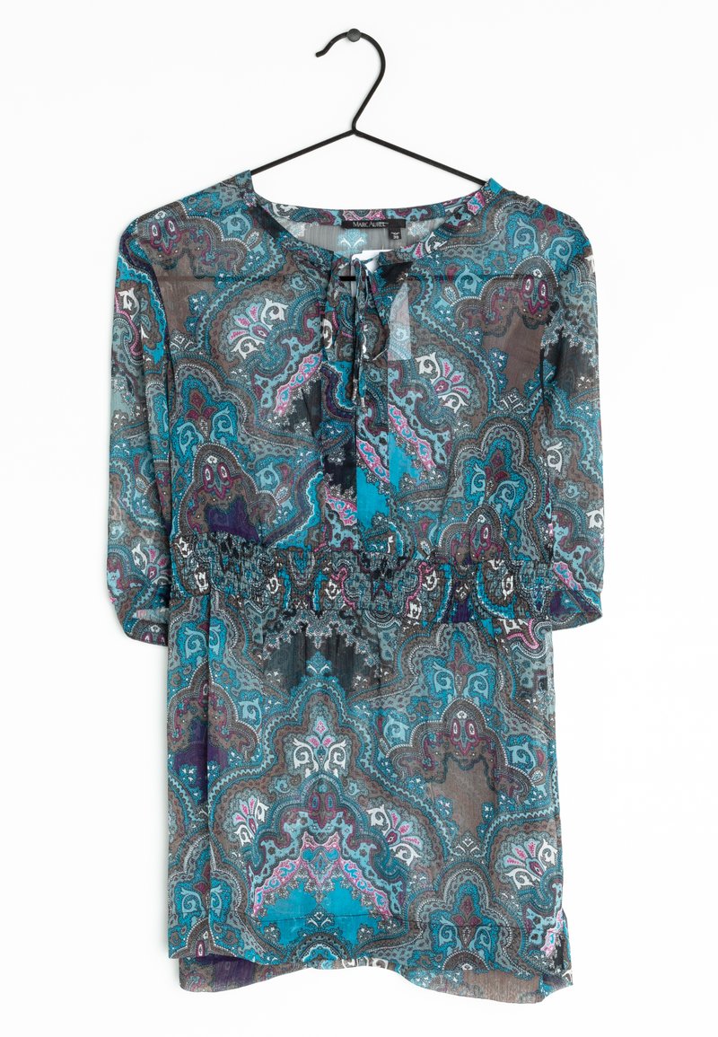 Blouse transparente à motifs avec un design paisley bleu, gris et violet. Dotée d'un col rond, de détails à nouer et de manches trois quarts.