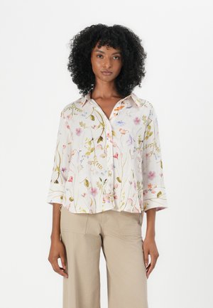 White blouse with a floral pattern featuring pink, yellow, and blue flowers. It has a button-up front, collar, and 3/4 sleeves.