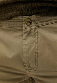 Pantaloni din bumbac bej cu închidere prinbuton și detalii de cusătură vizibile, având o textură netedă și o croială confortabilă.