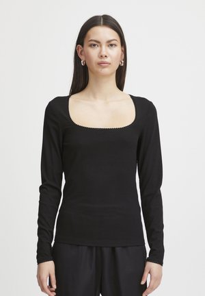 Haut noir à manches longues avec un décolleté carré, en tissu côtelé texturé, et de délicates accents festonnés le long du décolleté et des poignets.