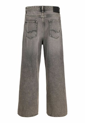 Leveälahkeisten, haalistuneiden harmaiden farkkujen takakatsaus, joissa on kaksi ommeltua takataskua ja musta vyötärönauhavyö.