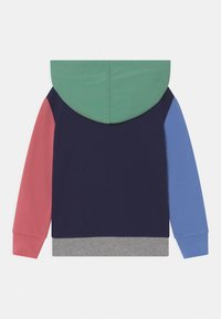 Värikäs huppari, jossa on vihreä huppu, tummansininen vartalo, vaaleanpunainen vasen hiha ja sininen oikea hiha. Siinä on harmaa resorireuna ja pehmeä kangaspinta.