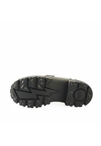 Black hiking boot sole with deep tread patterns, featuring zigzag design and circular logo, made from durable rubber material.