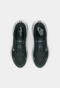 Μαύρα αθλητικά παπούτσια με υφή στο επάνω μέρος, κορδόνια και ανακλαστικές λεπτομέρειες. Διαθέτουν λογότυπο στη γλώσσα και μαλακή σόλα.